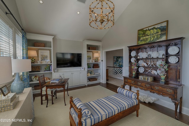 living area with wood finished floors, baseboards, visible vents, high vaulted ceiling, and an inviting chandelier