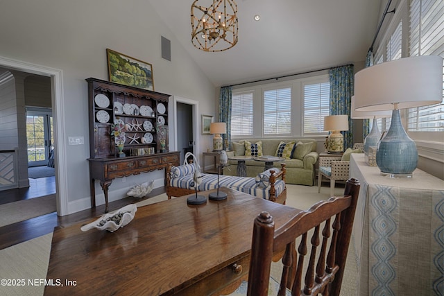 dining room featuring visible vents, baseboards, an inviting chandelier, wood finished floors, and high vaulted ceiling