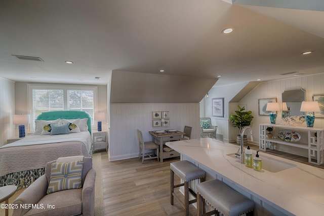 bedroom featuring recessed lighting, visible vents, light wood-style flooring, and a sink