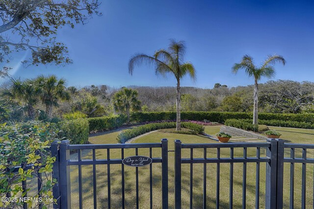 view of yard with a fenced front yard and a wooded view