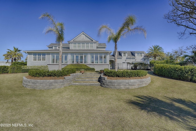 rear view of house featuring stairway and a lawn