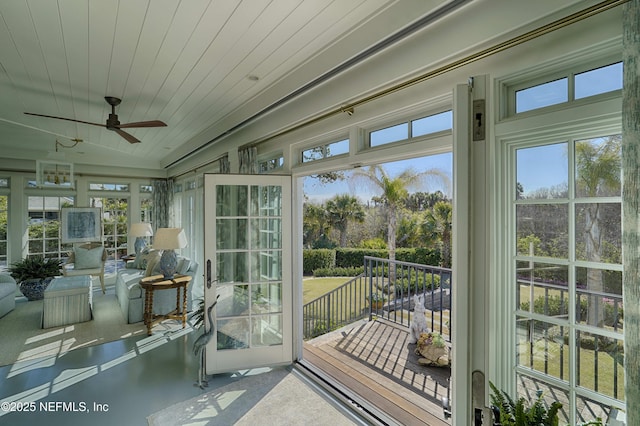 sunroom / solarium featuring wood ceiling, plenty of natural light, and a ceiling fan