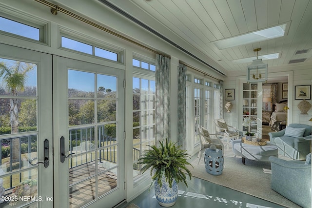 sunroom featuring french doors, visible vents, a skylight, and wooden ceiling