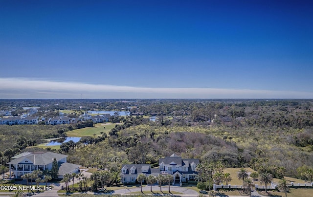 drone / aerial view with a wooded view and a water view