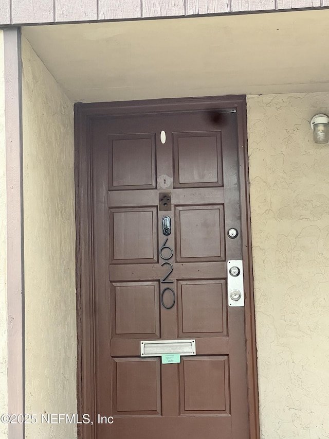 view of exterior entry featuring stucco siding