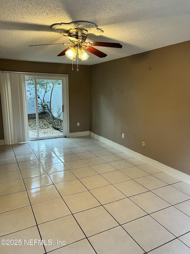 unfurnished room featuring light tile patterned flooring, ceiling fan, a textured ceiling, and baseboards