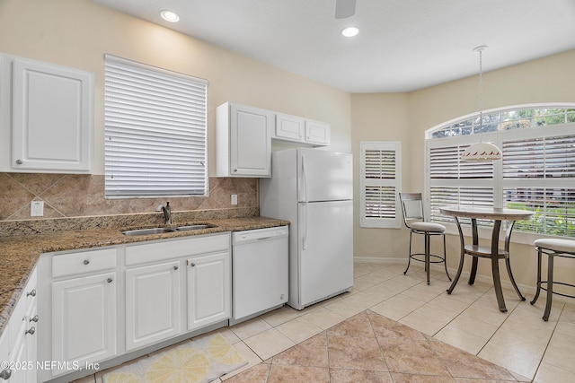 kitchen with light tile patterned floors, white appliances, a sink, white cabinetry, and tasteful backsplash