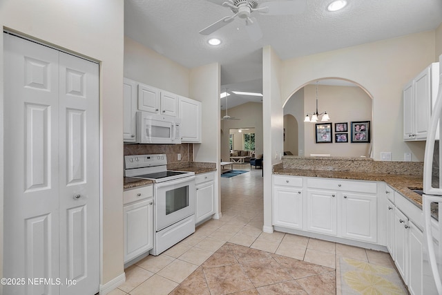 kitchen featuring arched walkways, light tile patterned floors, a ceiling fan, white cabinetry, and white appliances