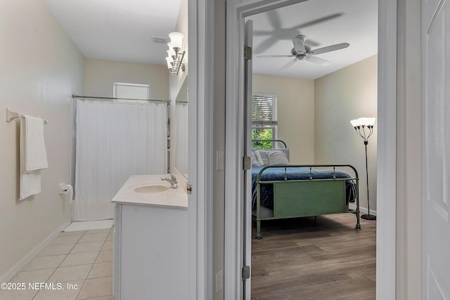 bathroom with tile patterned floors, ceiling fan, baseboards, and vanity