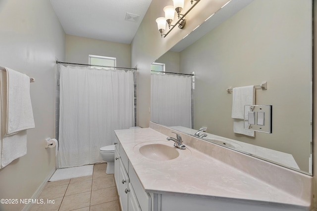 bathroom featuring tile patterned flooring, toilet, vanity, visible vents, and baseboards