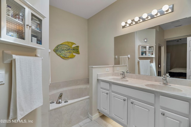 bathroom featuring double vanity, ensuite bath, tile patterned flooring, and a sink