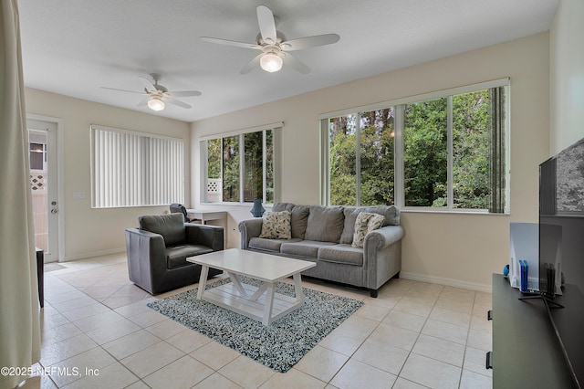 living area with plenty of natural light, baseboards, and light tile patterned flooring