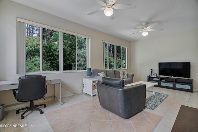 living room featuring a healthy amount of sunlight, light tile patterned flooring, ceiling fan, and baseboards