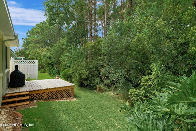 view of yard featuring fence and a deck