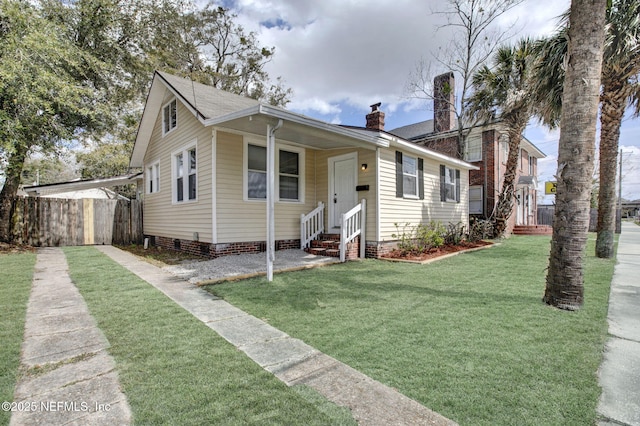 bungalow with a chimney, a front yard, crawl space, entry steps, and fence