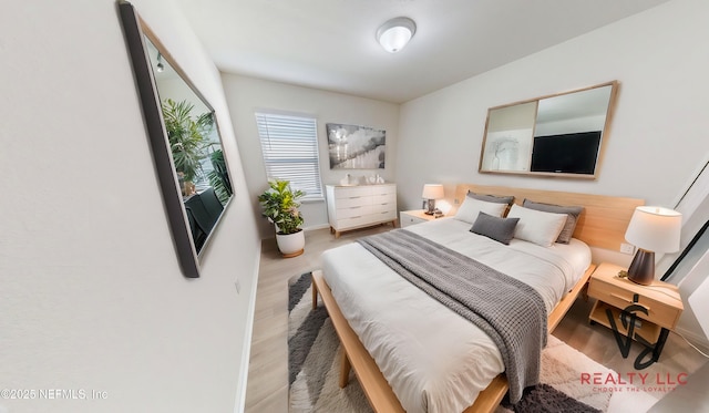 bedroom with baseboards and wood finished floors