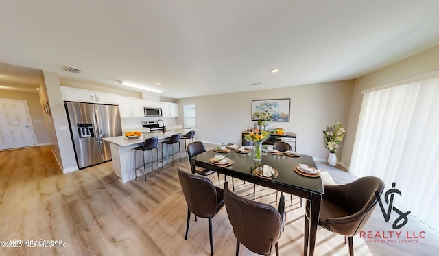 dining room with recessed lighting, light wood-type flooring, visible vents, and baseboards