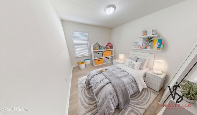 bedroom with wood finished floors and baseboards