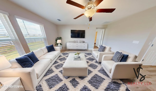 living area with visible vents and ceiling fan