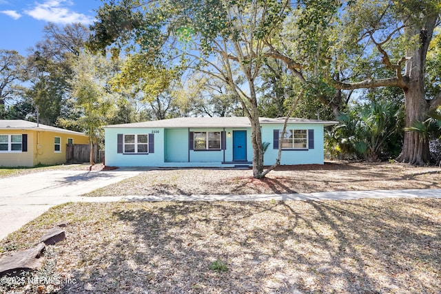 ranch-style house featuring fence