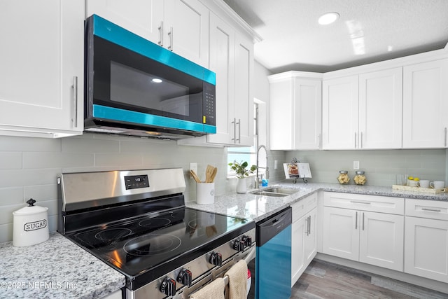 kitchen with a sink, stainless steel electric range, white cabinets, and dishwasher