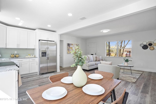 dining room featuring light wood-style floors, baseboards, visible vents, and recessed lighting