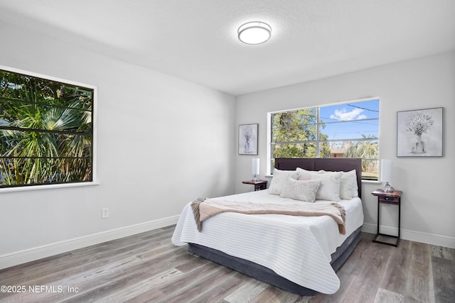 bedroom with wood finished floors and baseboards