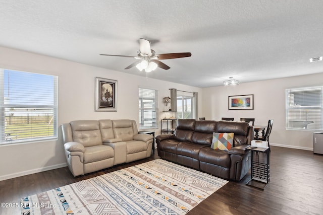 living room with dark wood-style floors, baseboards, and a textured ceiling