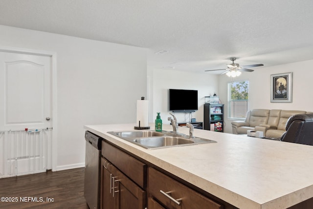 kitchen featuring an island with sink, open floor plan, light countertops, stainless steel dishwasher, and a sink