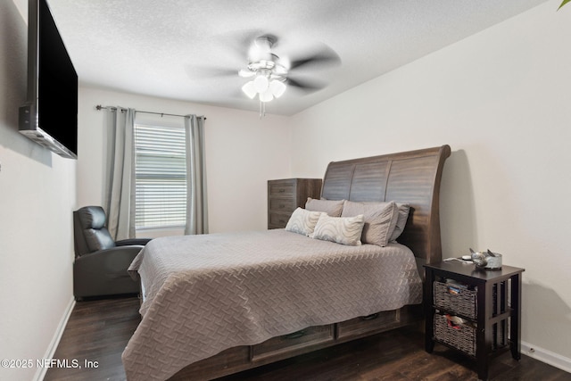 bedroom with a textured ceiling, dark wood finished floors, a ceiling fan, and baseboards