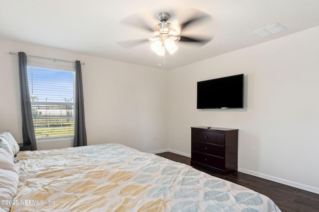 bedroom featuring baseboards, visible vents, dark wood finished floors, and a ceiling fan