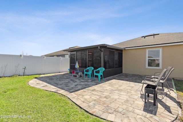 view of patio / terrace featuring fence and a sunroom