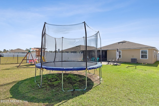 view of yard with a trampoline, a playground, fence, and cooling unit