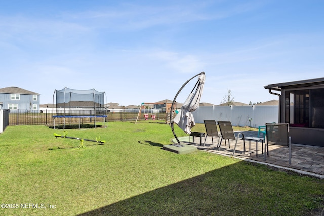 view of yard with a patio, a trampoline, and a fenced backyard