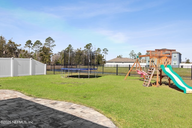 view of yard with a patio area, a fenced backyard, a trampoline, and a playground