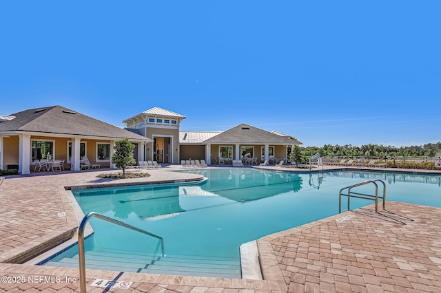 pool with a patio area and fence