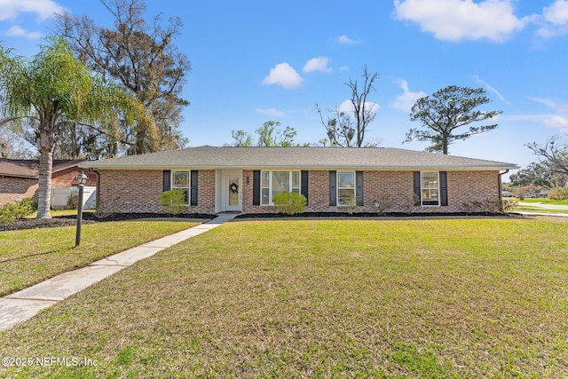 ranch-style home featuring brick siding and a front yard