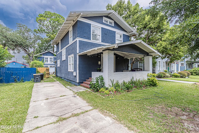 american foursquare style home with fence and a front lawn