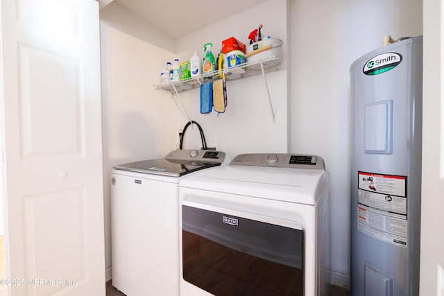 laundry room featuring laundry area, washing machine and clothes dryer, wood finished floors, and electric water heater