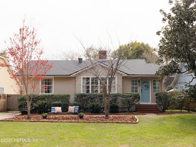 ranch-style home with roof with shingles, a chimney, a front yard, and fence