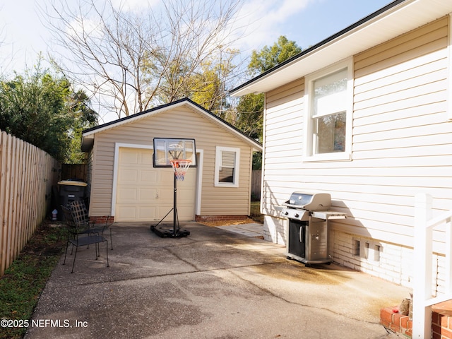 view of patio / terrace with driveway, a garage, a fenced backyard, grilling area, and an outdoor structure