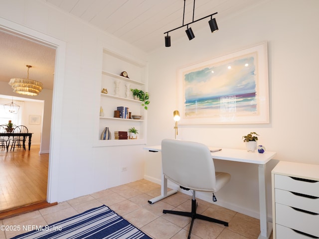 home office with light tile patterned floors, crown molding, an inviting chandelier, and built in features