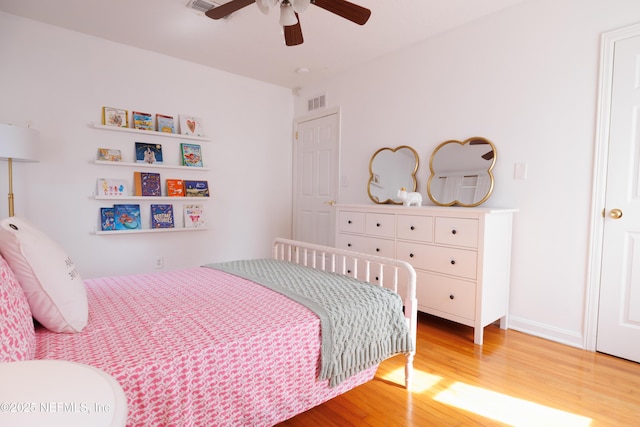 bedroom featuring a ceiling fan, visible vents, and light wood finished floors