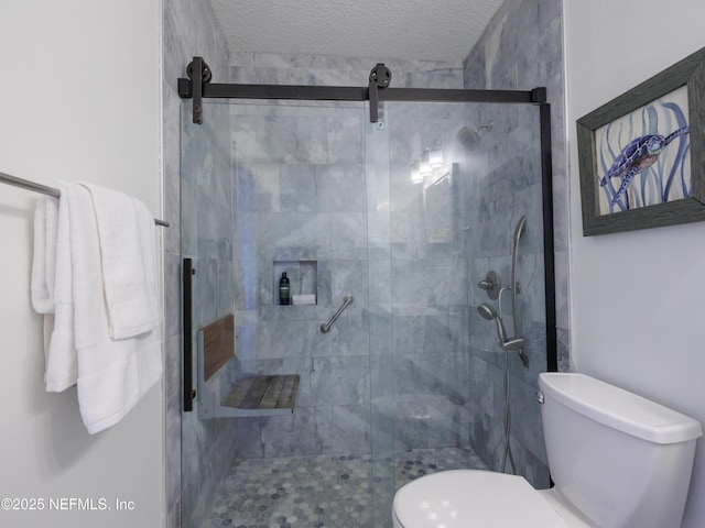 full bath featuring toilet, a shower stall, and a textured ceiling