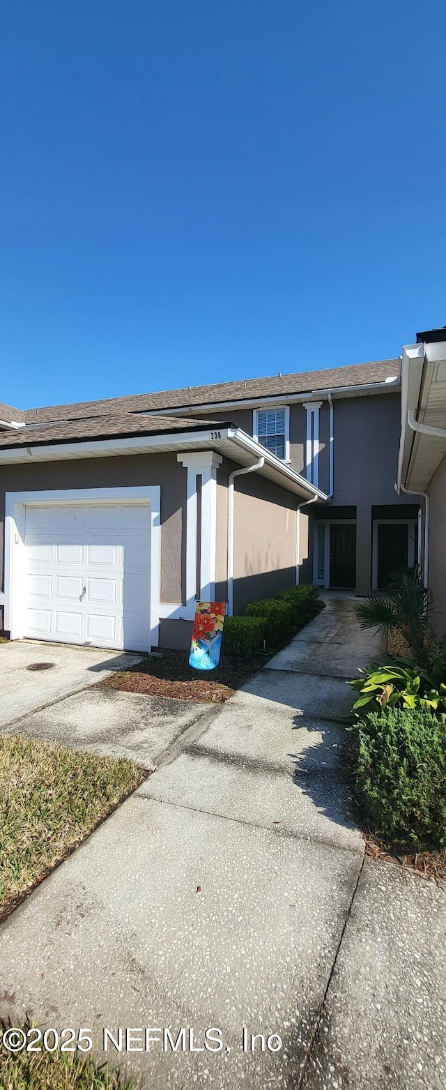 view of side of home with a garage and stucco siding