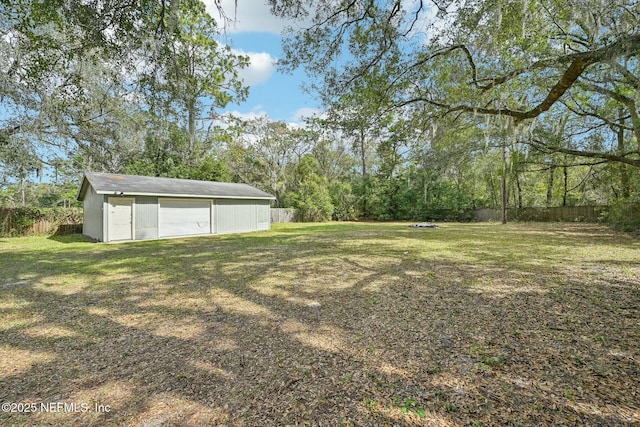 view of yard with an outbuilding, fence, and a garage