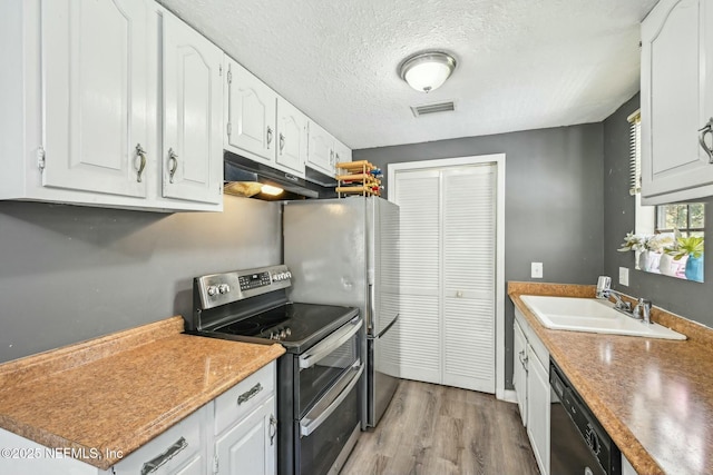 kitchen featuring visible vents, a sink, double oven range, dishwasher, and under cabinet range hood