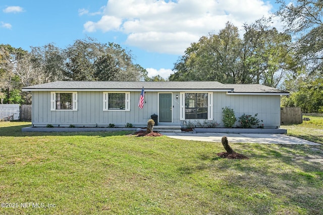 view of front of house with a patio, a front lawn, and fence