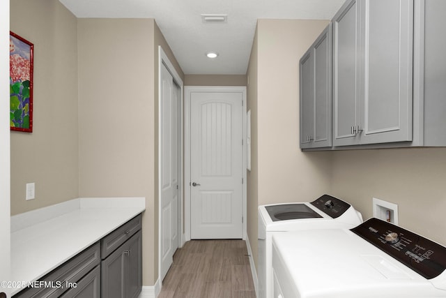 clothes washing area featuring recessed lighting, separate washer and dryer, visible vents, light wood-style floors, and cabinet space