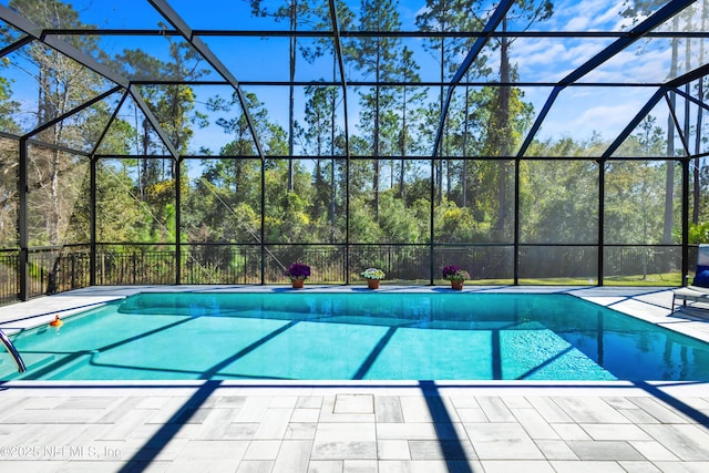 view of swimming pool with glass enclosure, a fenced in pool, and a patio